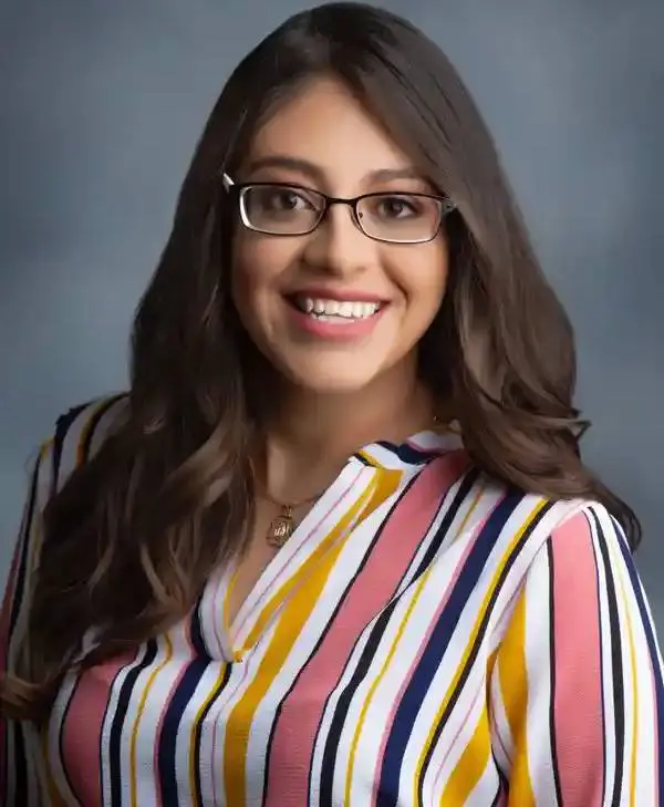 A woman with glasses and long hair wearing a striped shirt.