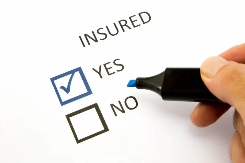 A person is filling out an insured form.