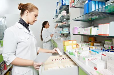 Two women in a pharmacy looking at the shelves.
